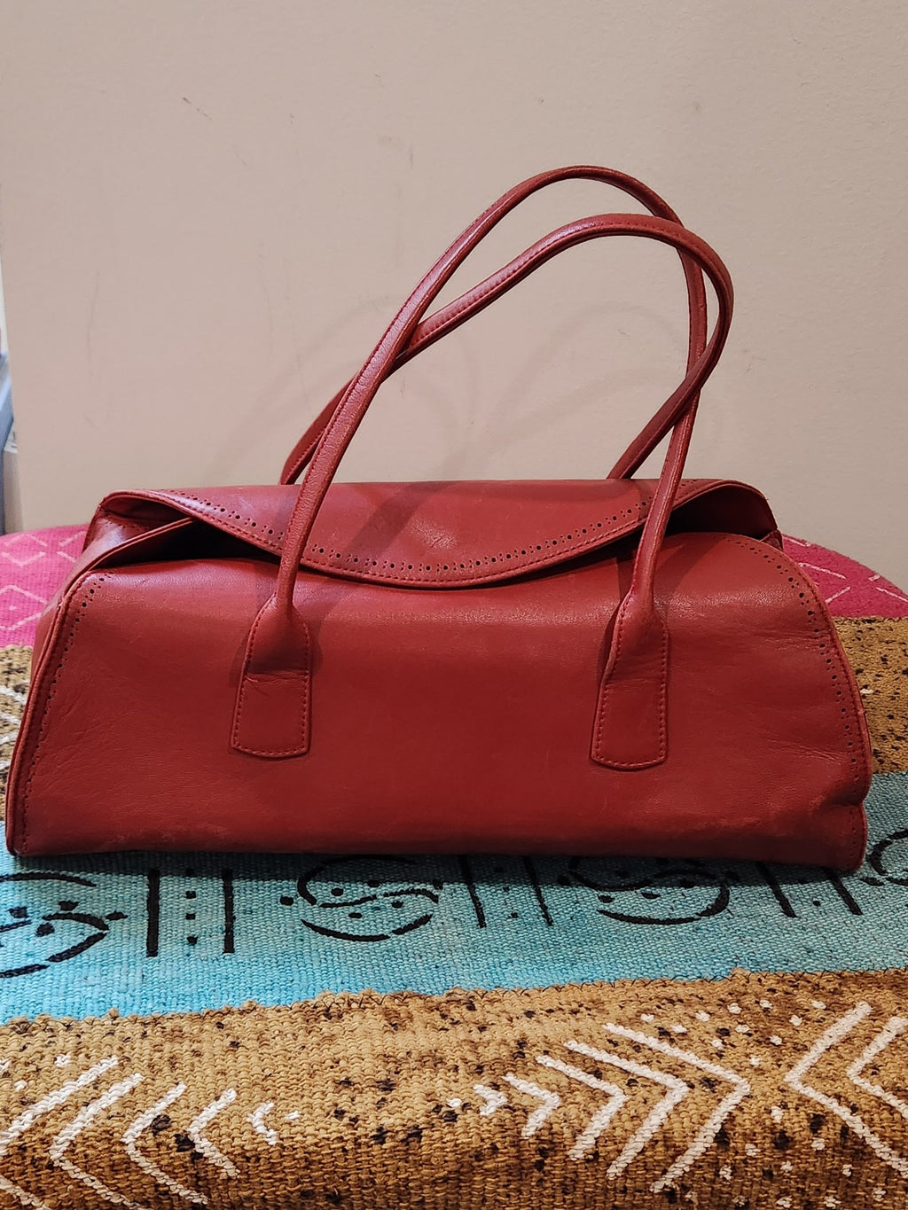 Front view of vintage Robinson Valentine brick-red leather barrel shoulder bag