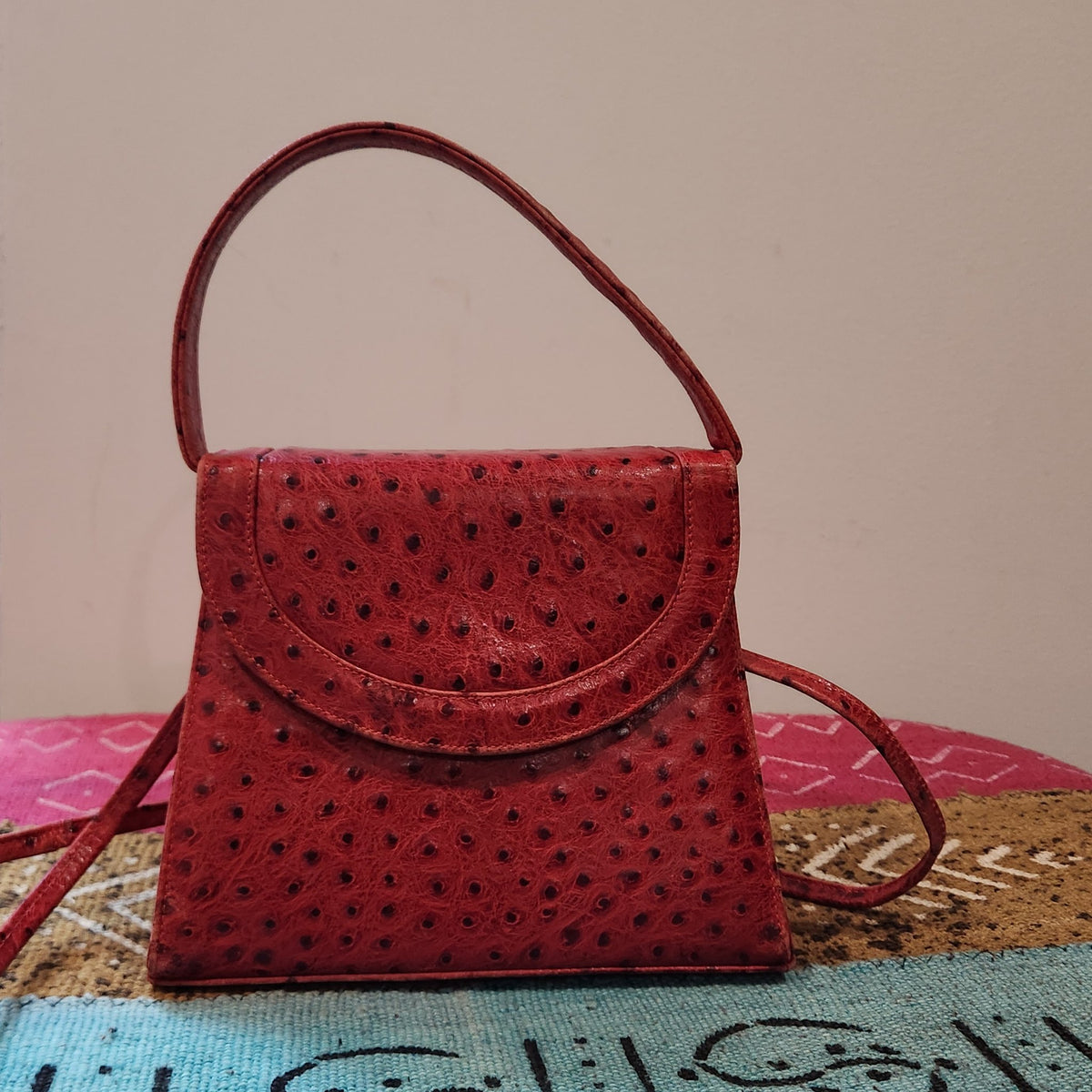 Front view of vintage Mike's Collection red ostrich-embossed leather mini handbag with rounded flap