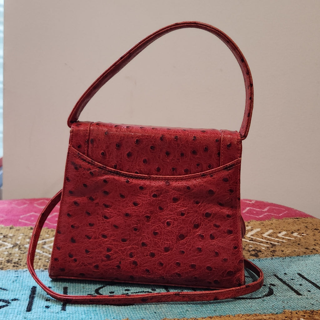 Back view of vintage Mike's Collection red ostrich-embossed leather mini handbag, showing the exterior slip pocket