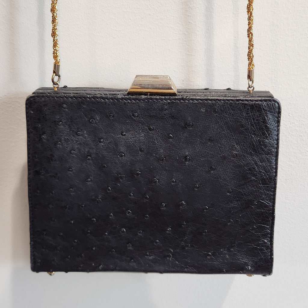 Front view of vintage Beoni Lucia black ostrich-textured leather evening bag with gold-tone geometric frame clasp and braided gold chain strap