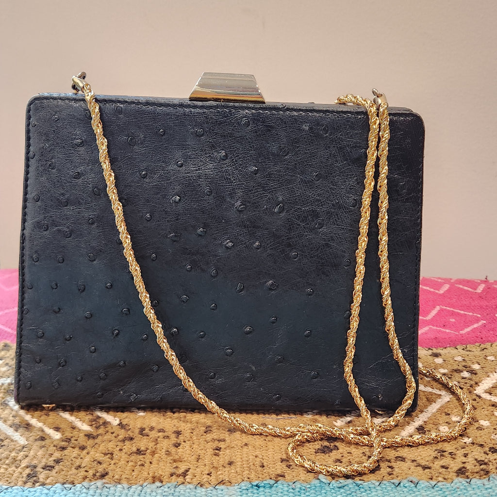 Top view of vintage Beoni Lucia black ostrich-textured leather evening bag, showing side gusset, structured depth and gold-tone clasp