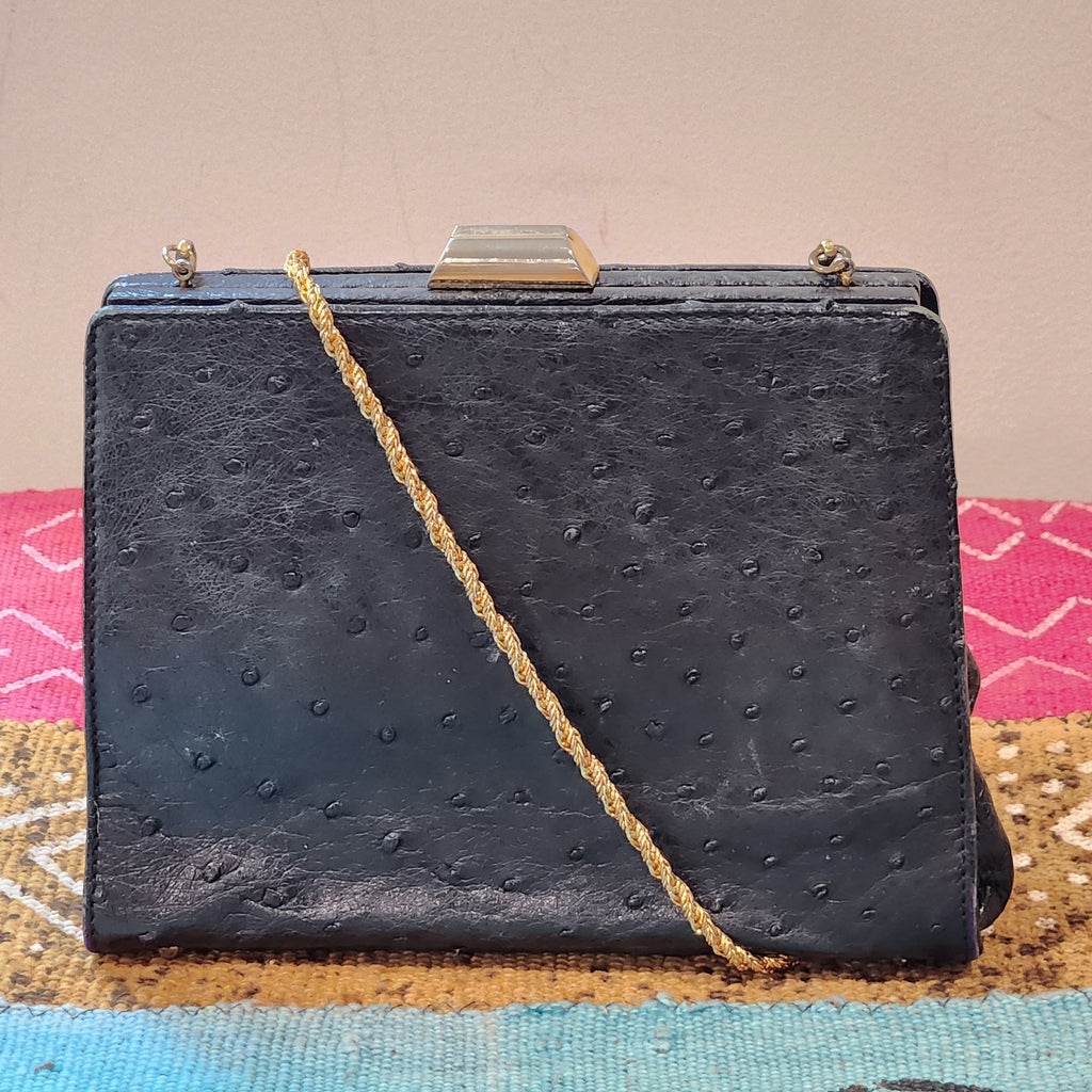 Front view of vintage Beoni Lucia black ostrich-textured leather evening bag with braided gold chain strap draped across the body
