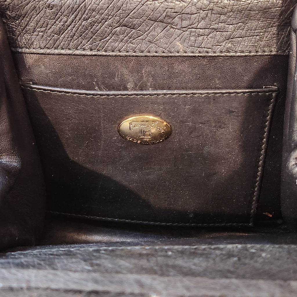 Interior slip pocket of vintage Beoni Lucia black evening bag with gold oval Beoni Lucia designer plaque, showing lining wear