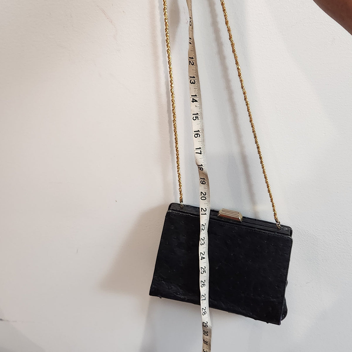 Chain drop measurement of vintage Beoni Lucia black evening bag, tape measure alongside the hanging braided gold chain showing approximately 21 inches