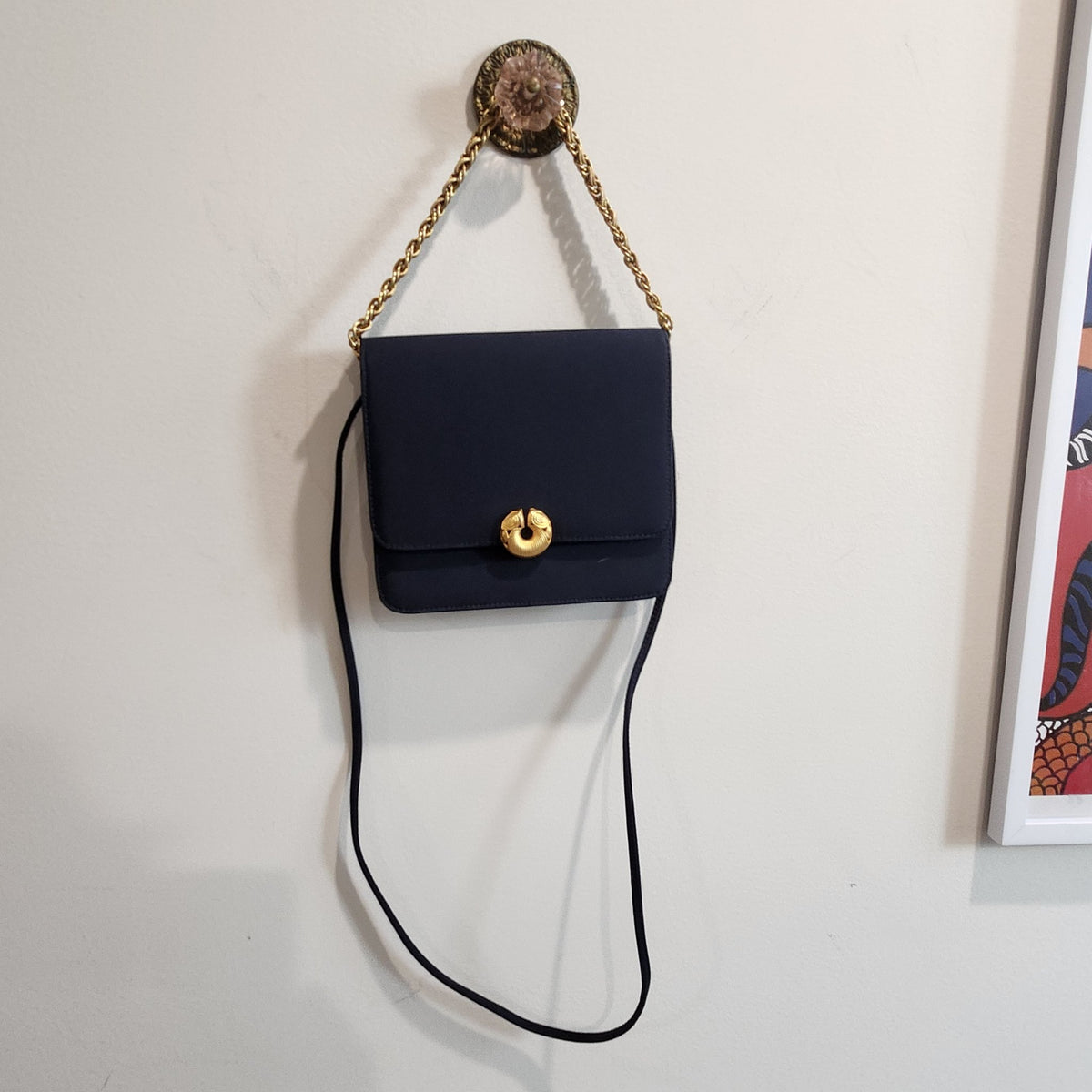 Original photo: vintage Kenneth Jay Lane midnight navy flap bag hanging by its gold chain, long navy strap hanging below