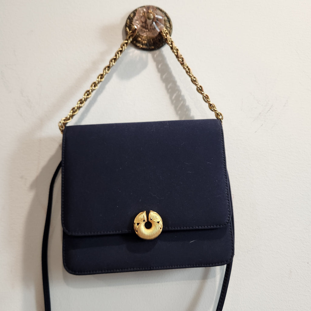 Original photo: close front view of the vintage Kenneth Jay Lane midnight navy flap bag hanging by its gold chain