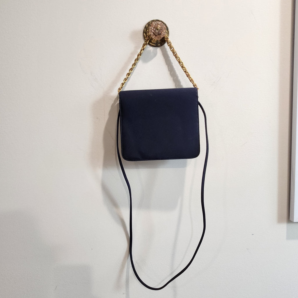 Original photo: back view of the vintage Kenneth Jay Lane midnight navy flap bag hanging by its gold chain