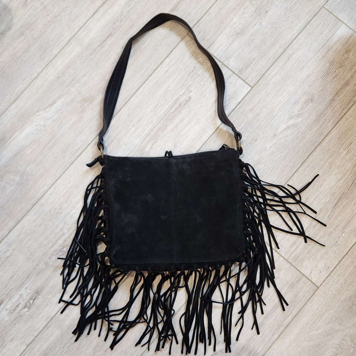 Original photo: vintage EGO black suede fringe shoulder bag, back view on a light wood floor