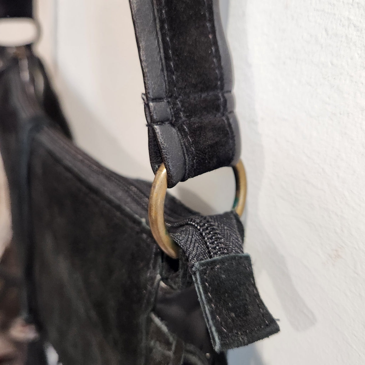 Original photo: close-up of the antique-tone ring hardware where the strap meets the bag body