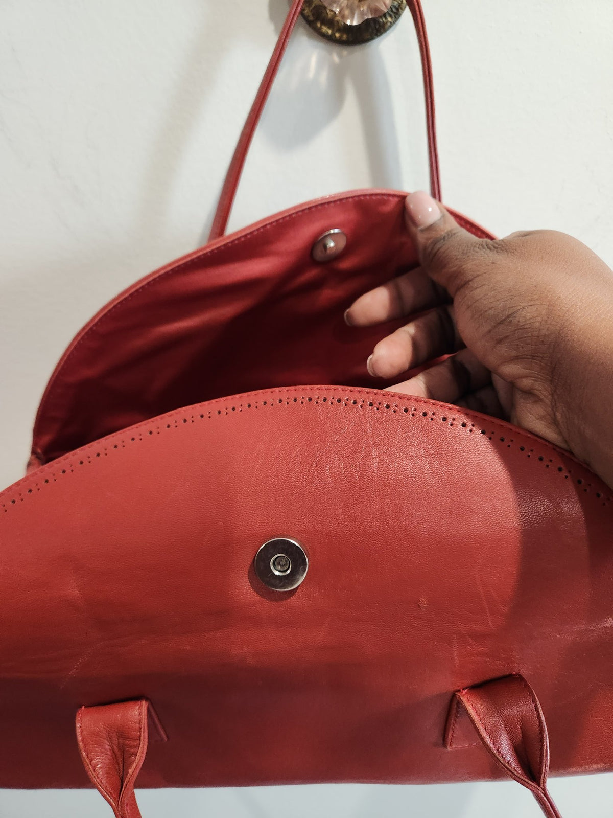 Interior of vintage Robinson Valentine brick-red leather barrel shoulder bag, showing coordinating lining and magnetic snap closure