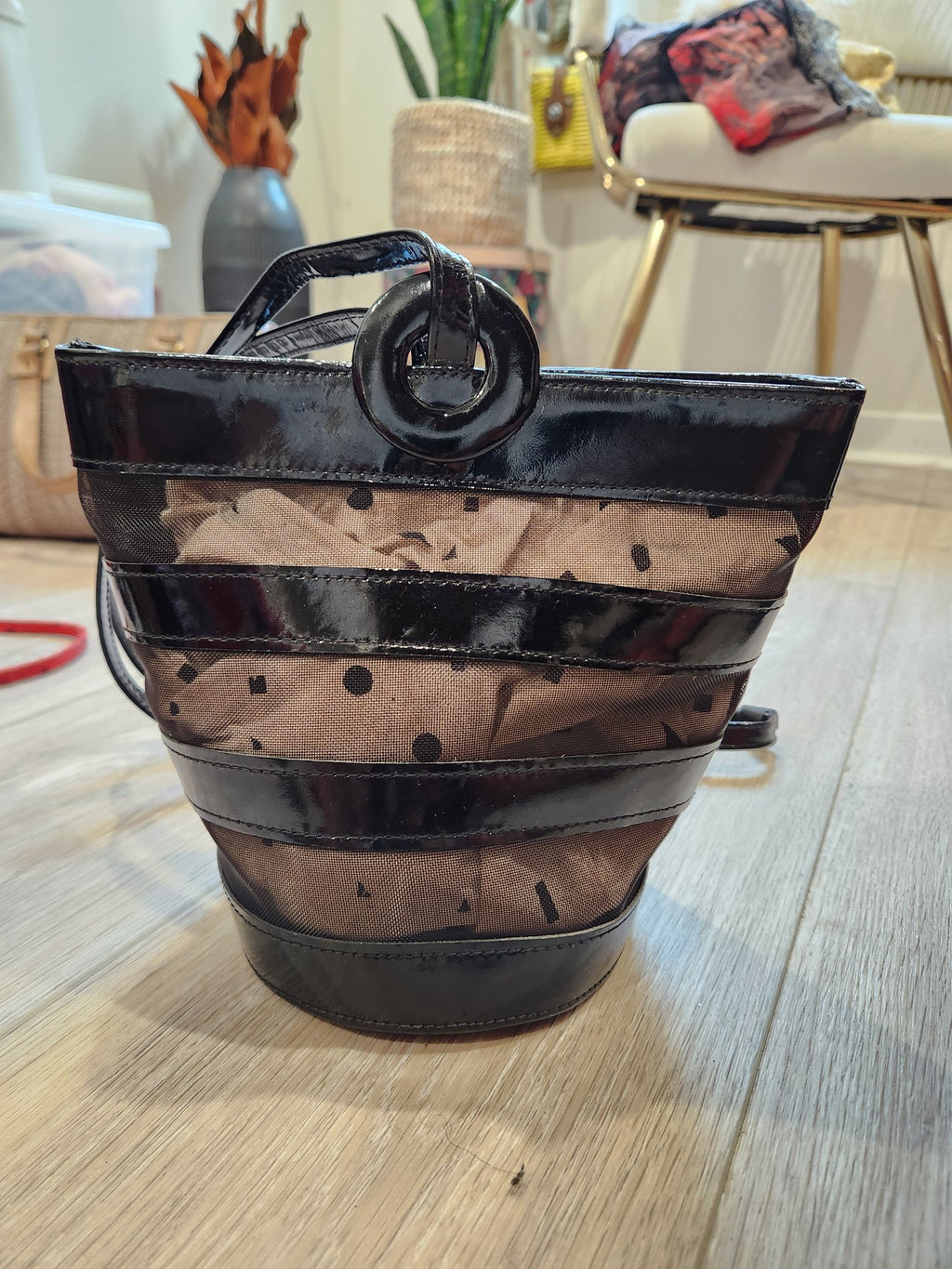 Front three-quarter view of vintage Linda Allard for Ellen Tracy black patent leather and sheer polka-dot mesh bucket bag