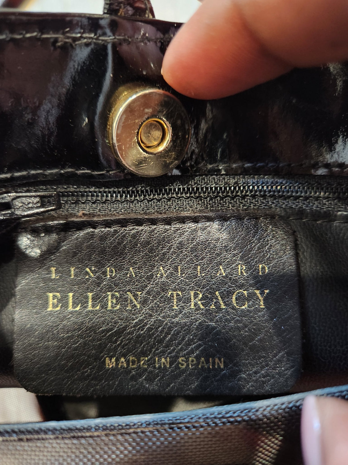 Interior label of vintage Linda Allard for Ellen Tracy bucket bag reading Linda Allard Ellen Tracy, Made in Spain, with magnetic snap closure and zippered pocket