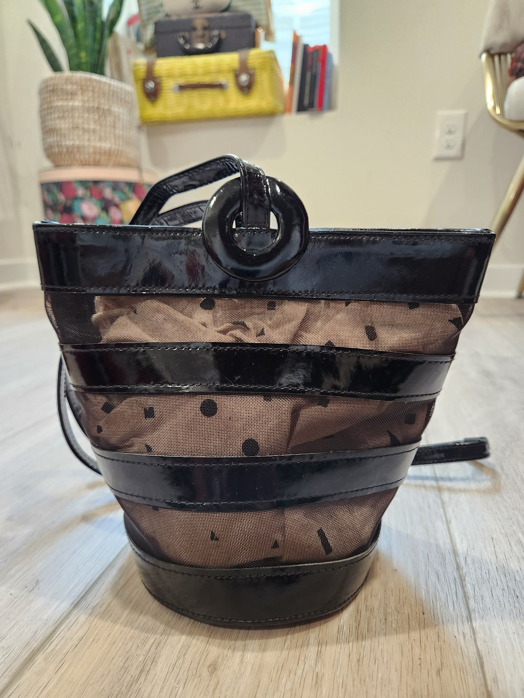 Closer front view of vintage Linda Allard for Ellen Tracy black patent leather and sheer patterned mesh bucket bag, showing texture and construction