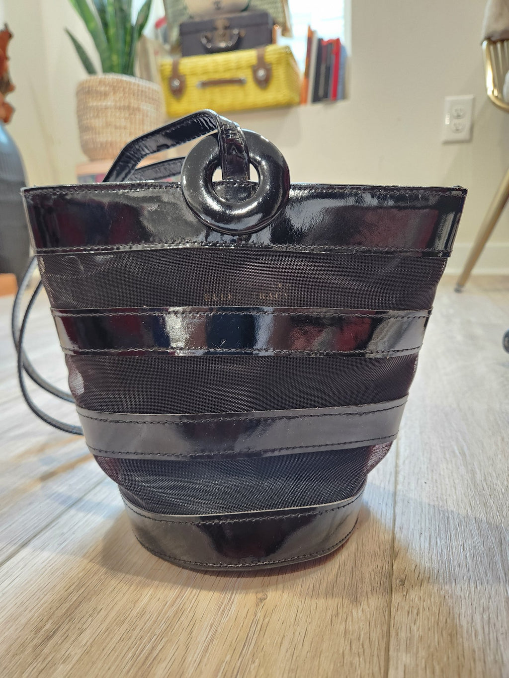 Front view of vintage Linda Allard for Ellen Tracy bucket bag with long slender shoulder strap and circular patent ring detail