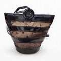Front view of vintage Linda Allard for Ellen Tracy black patent leather and sheer patterned mesh bucket bag on a white background