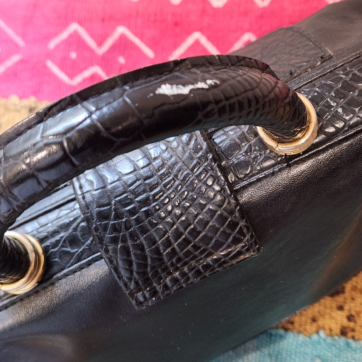 LaTique bag top handle showing wear along edges