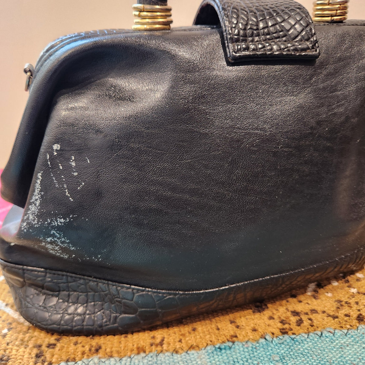 LaTique handbag side showing white scuff and finish loss