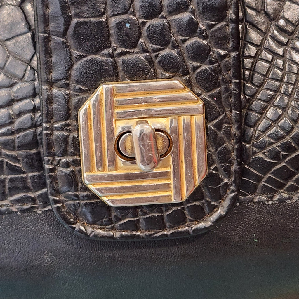 LaTique gold-tone octagonal turn-lock closure detail