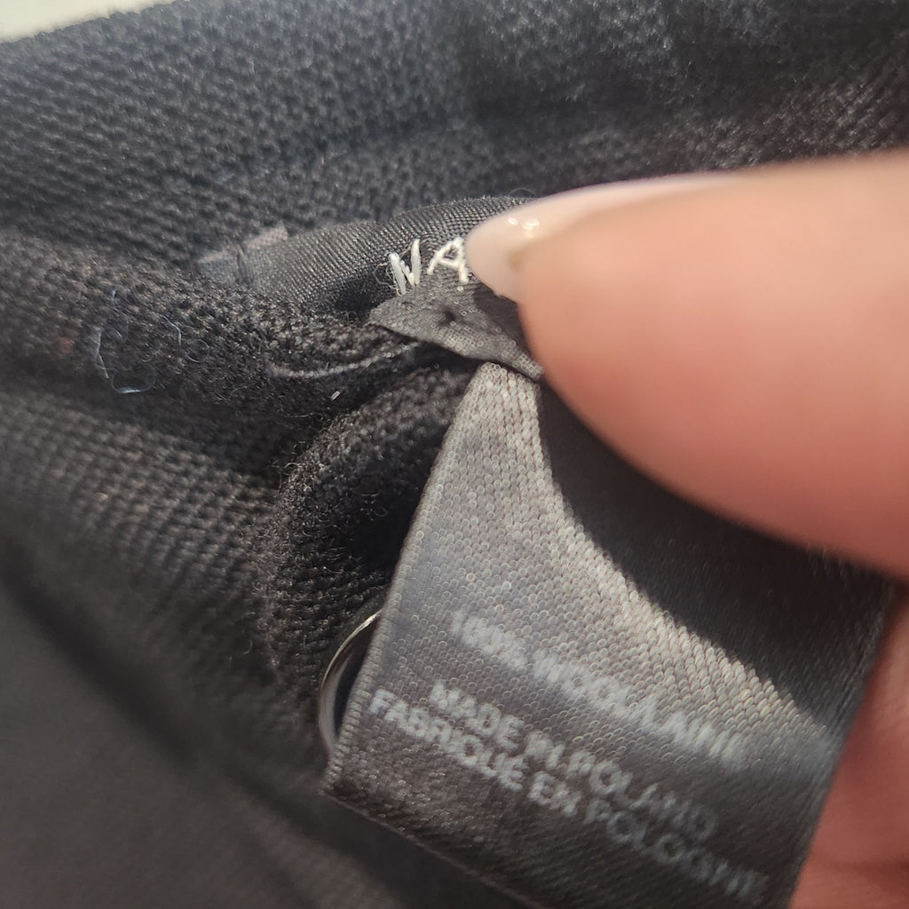 Lucille Golden Vintage, LLC black wool trousers care label showing 100% wool material and made in Poland tag