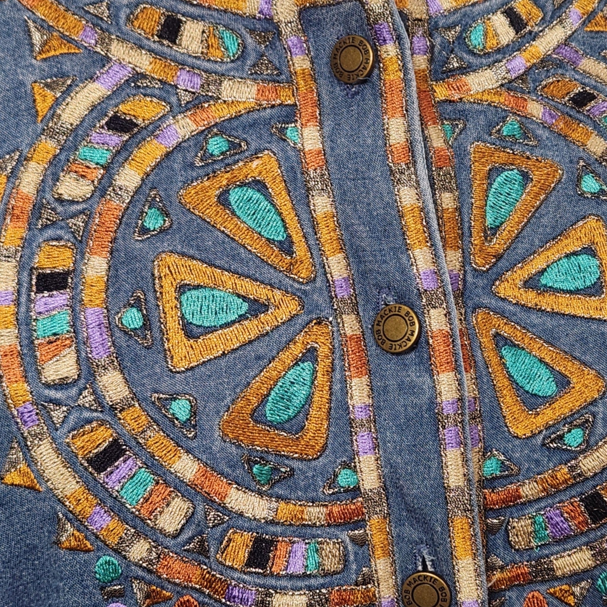 Lucille Golden Vintage, LLC denim shirt featuring intricate turquoise, gold, and purple geometric embroidery detail.