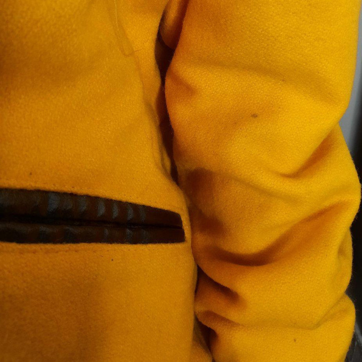 Lucille Golden Vintage, LLC gold wool varsity jacket sleeve detail showing leather pocket trim and vintage texture