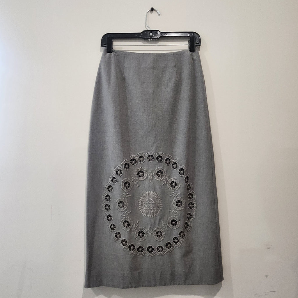Lucille Golden Vintage, LLC grey midi skirt with intricate circular laser-cut embroidery detail on the front.