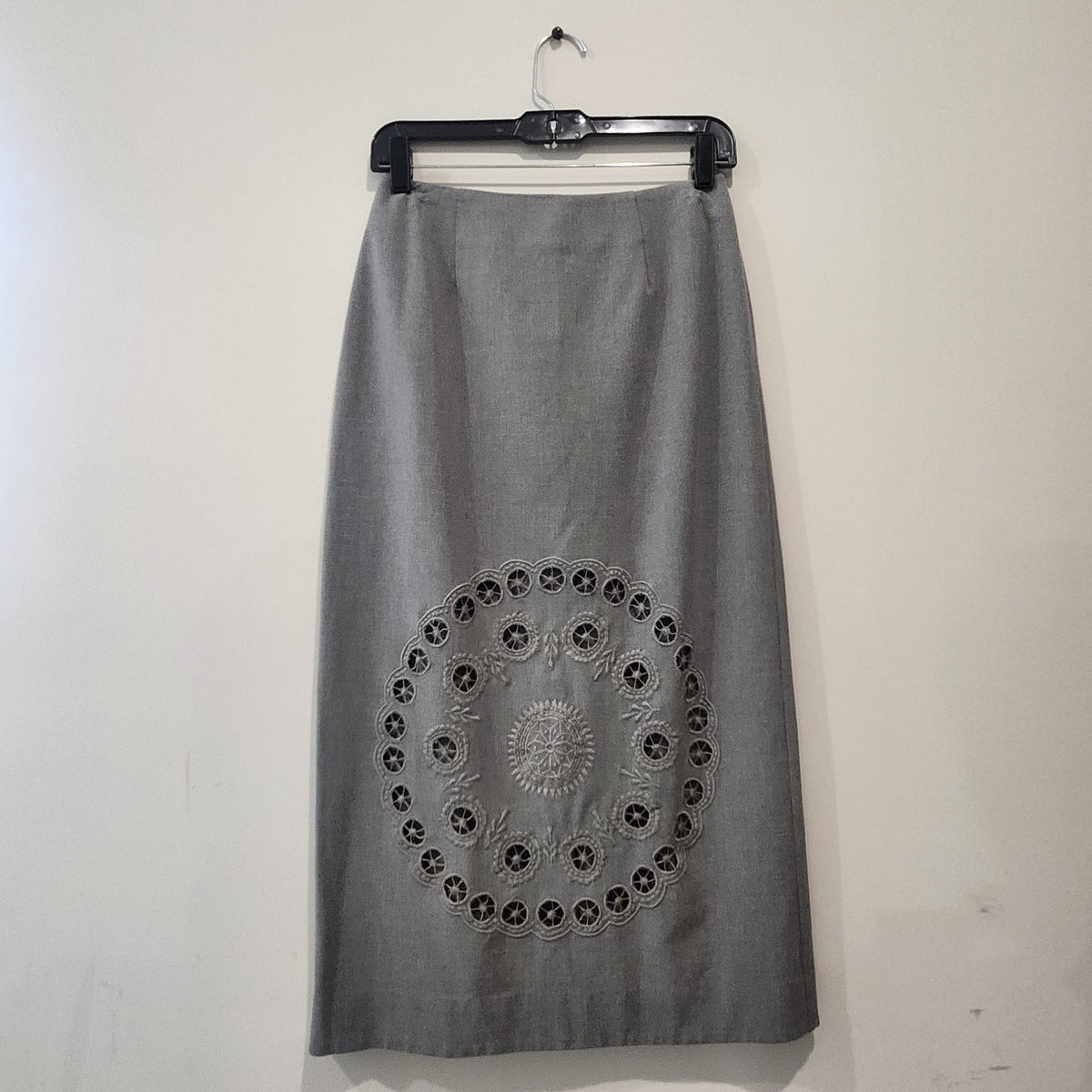 Lucille Golden Vintage, LLC grey midi skirt with intricate circular laser-cut embroidery detail on the front.