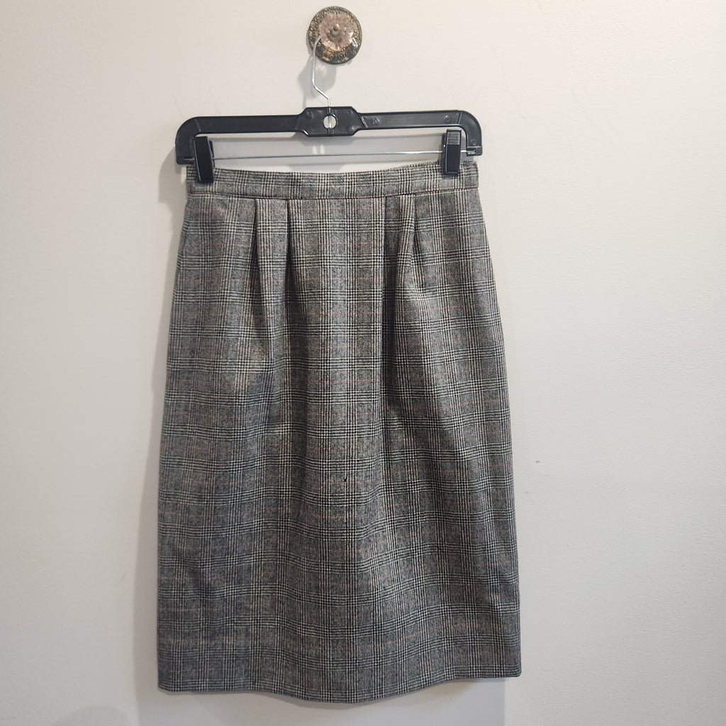 Lucille Golden Vintage, LLC grey glen plaid wool skirt with high-waisted pleated design hanging on a black hanger.