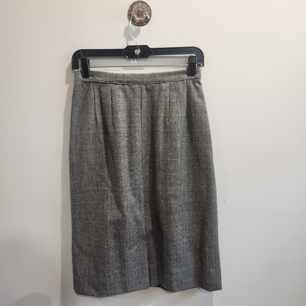 Lucille Golden Vintage, LLC grey glen plaid wool skirt with a high-waisted pleated design hanging on a hanger.