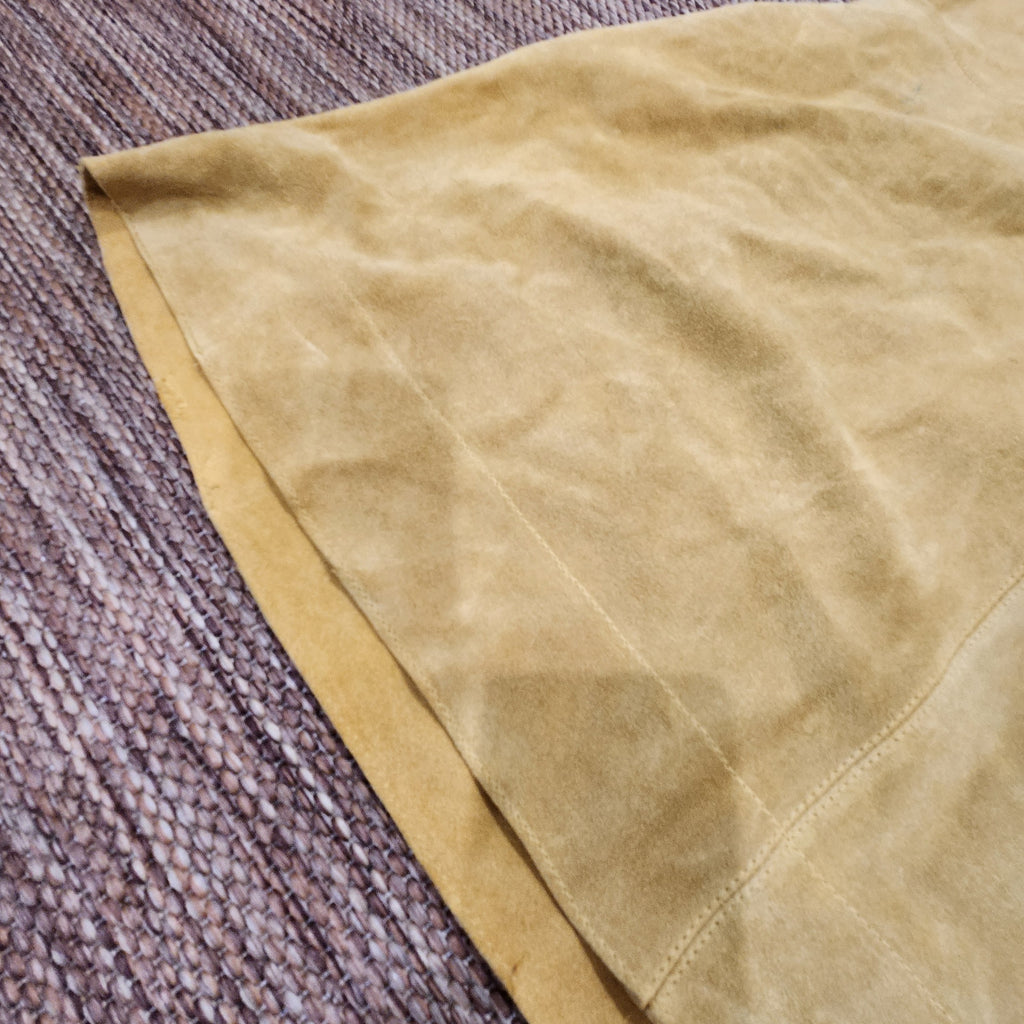 Close-up of mustard yellow suede fabric on a Free People mini dress from Lucille Golden Vintage, LLC