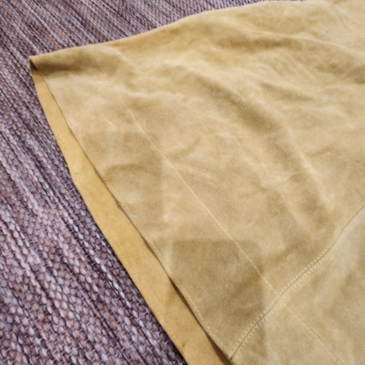Close-up of mustard yellow suede fabric on a Free People mini dress from Lucille Golden Vintage, LLC