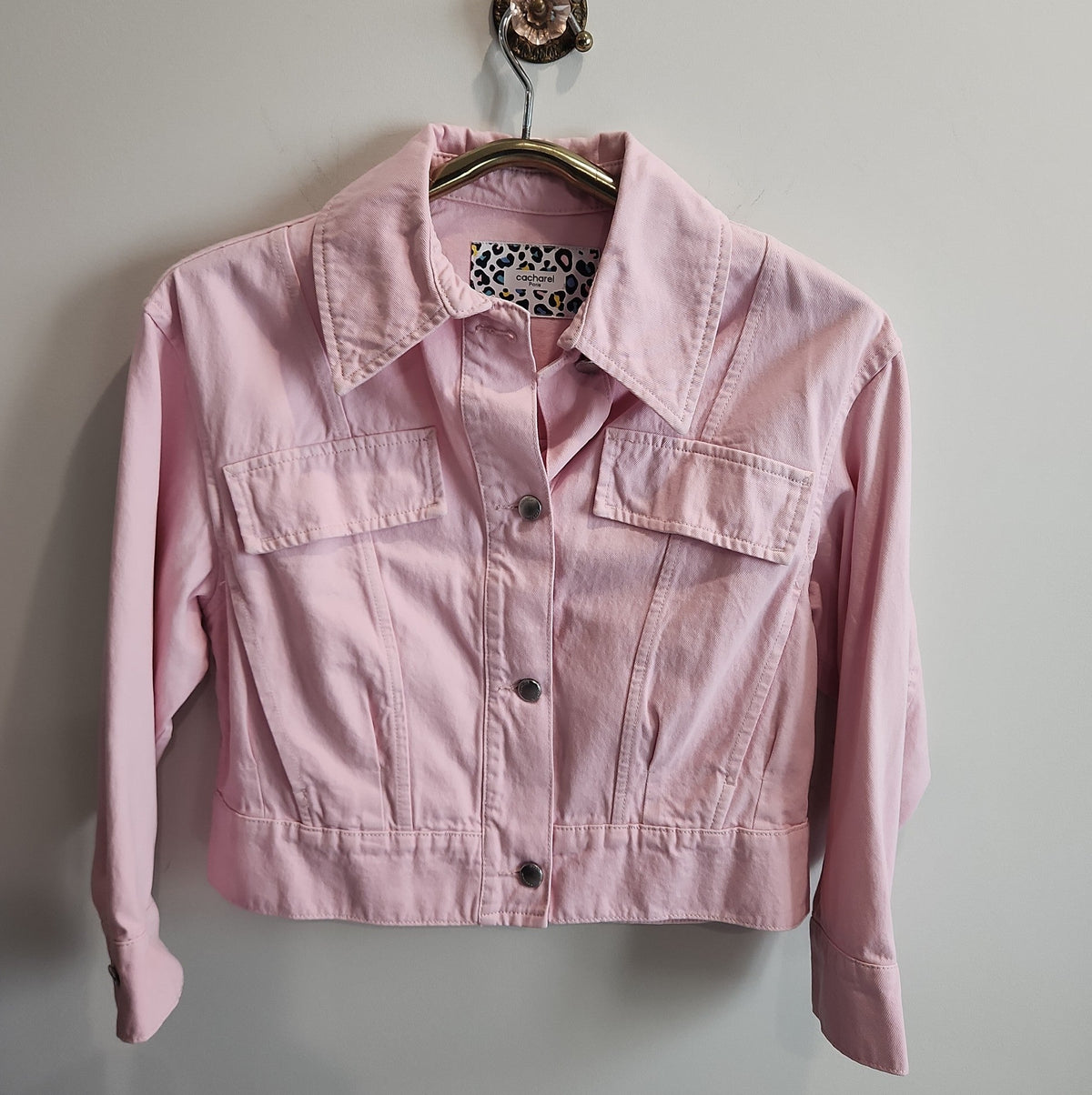 Lucille Golden Vintage, LLC pastel pink cropped denim jacket with button-front and leopard print neck label.