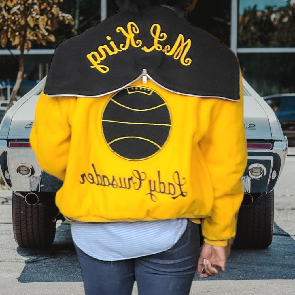 Lucille Golden Vintage, LLC 1990s gold and black wool varsity jacket with MLK hood and basketball back patch.