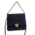 Vintage Kenneth Jay Lane midnight navy flap bag on a white background, front view, gold chain arranged above the bag